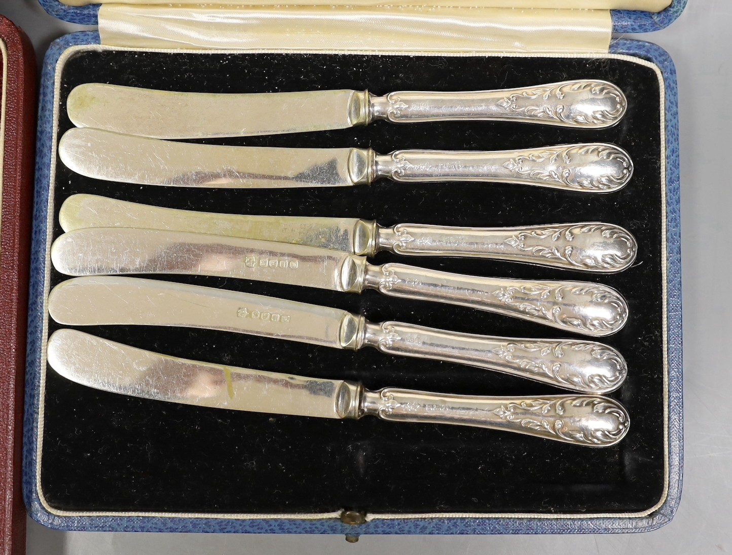 A cased set of George V silver Old English pattern soup spoons, Harrod's Ltd, Sheffield, 1934 and a cased set of six silver handled tea knives and sundry silver and white metal flatware.